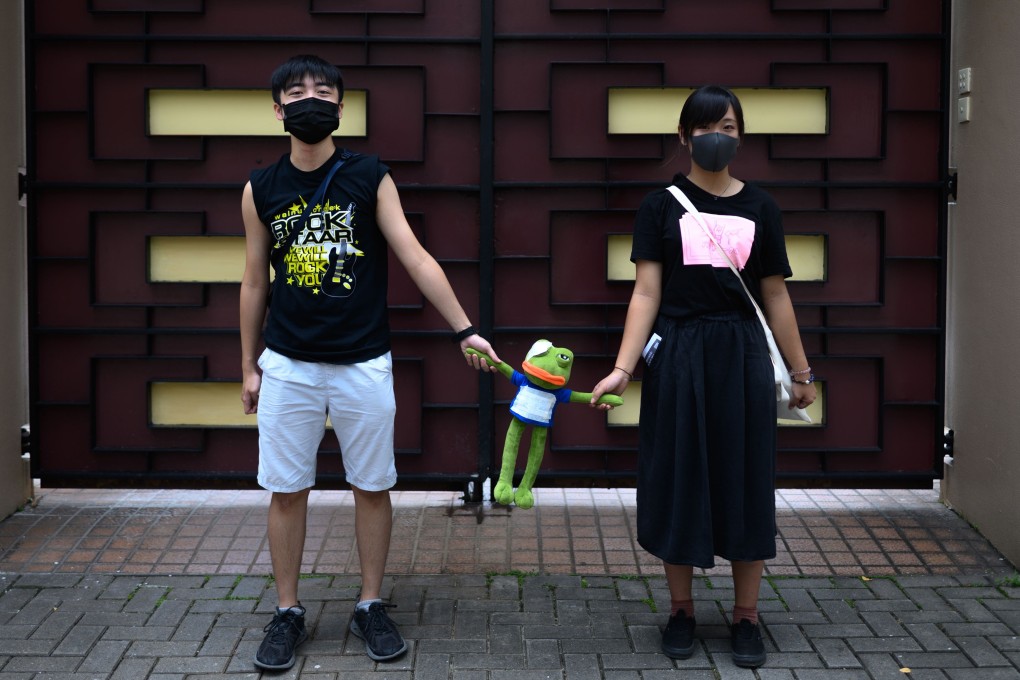 Two students join hands with a Pepe the Frog doll during a protest in Kowloon Tong on September 9. Photo: AFP
