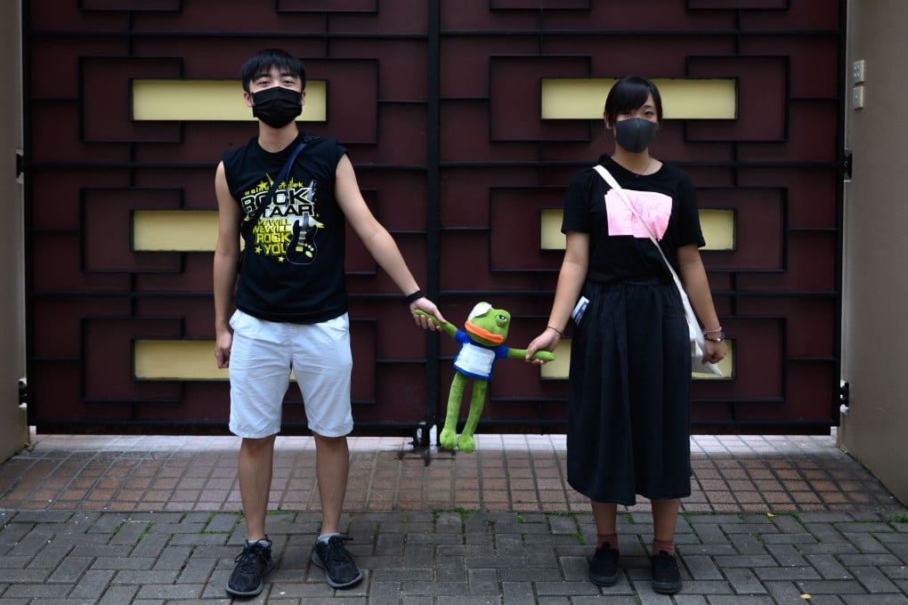 Two students join hands with a Pepe the Frog doll during a protest in Kowloon Tong on September 9. Photo: AFP