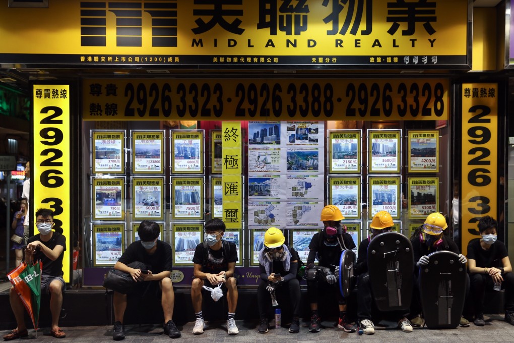 Protesters sit outside a closed real estate agent shop during a rally in Hong Kong on August 3. Photo: EPA-EFE