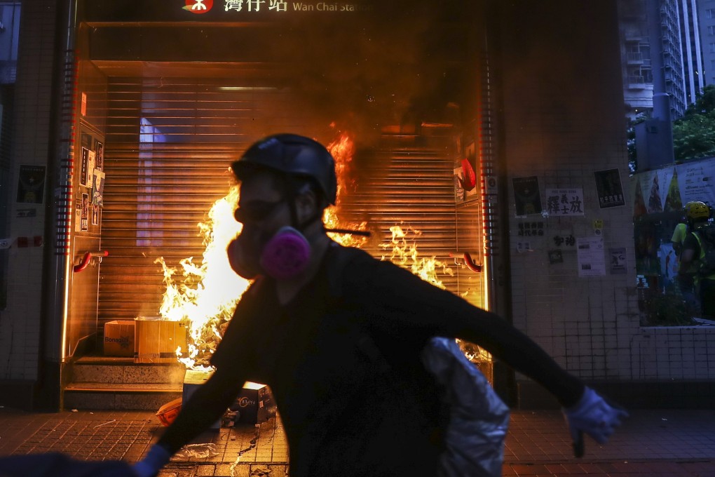 Protesters start a fire at the entrance of Wan Chai station as they continue their assault on the city’s rail network. Photo: Sam Tsang