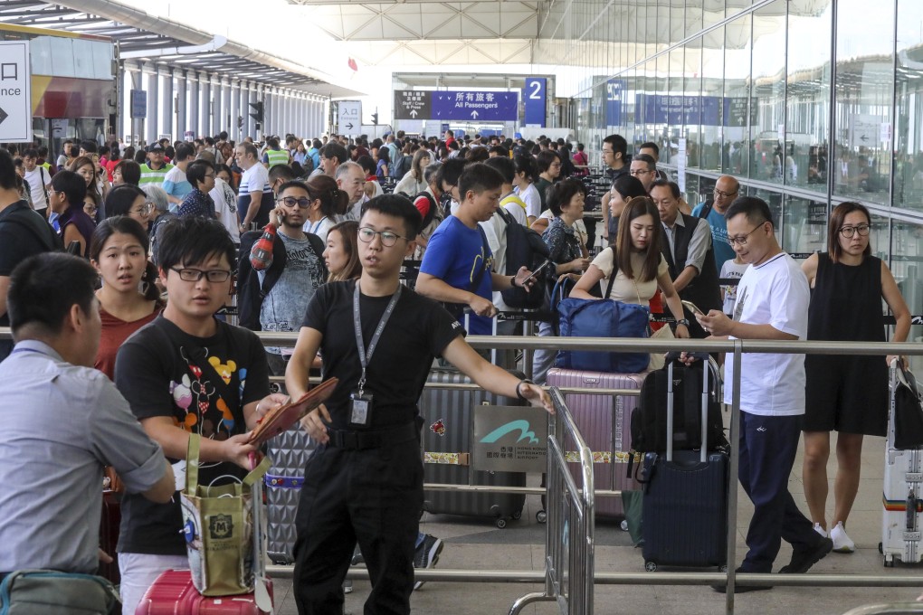 Travellers queue for security checks before entering Hong Kong International Airport on Sunday morning. Photo: K. Y. Cheng