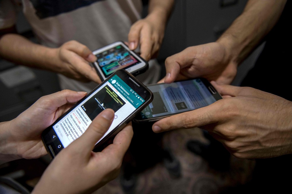 Patients from a therapeutic group on digital dependence show their cellphones inside a clinic in Rio de Janeiro, Brazil on October 20, 2017. Photo: AFP