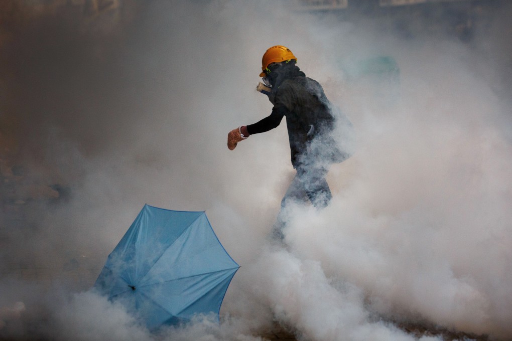 A Hong Kong protester walks in a cloud of tear gas. Photo: Bloomberg