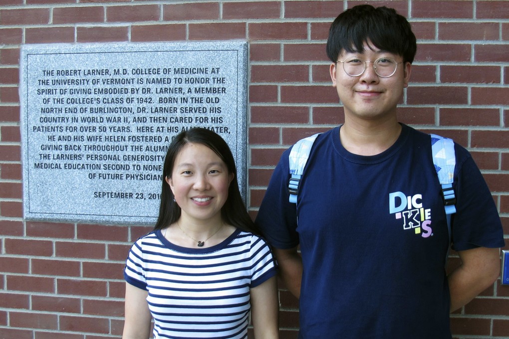 Chinese graduate students Li Zhaojin (left) and Liu Pengfei pose in front of the entrance to the Robert Larner College of Medicine at the University of Vermont in Burlington in August. Photo: AP