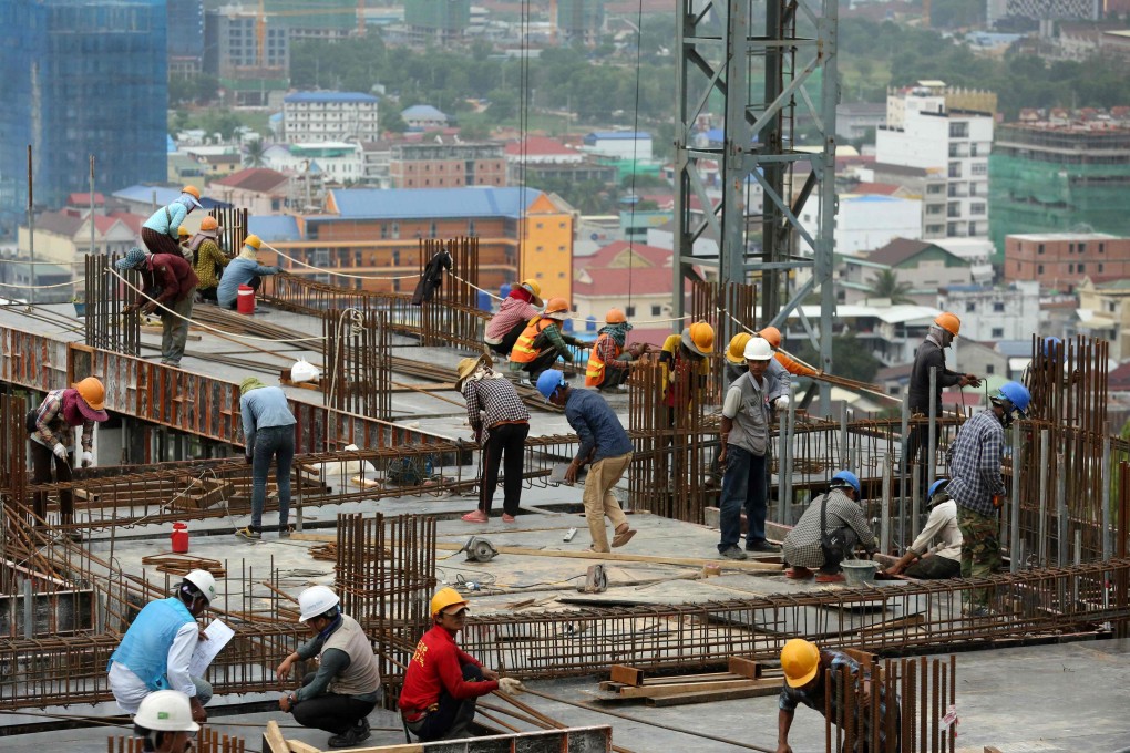 Cambodians work on a high-rise building site in Sihanoukville. The city has been transformed by a construction boom driven by Chinese cash. Photo: AFP