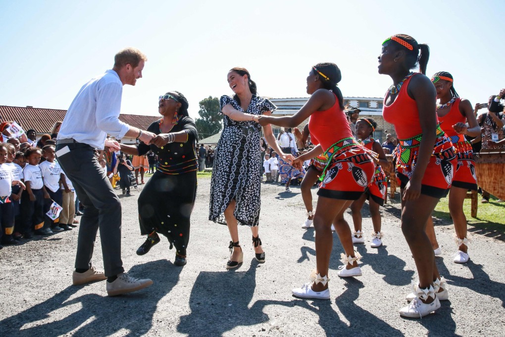 Britain's Meghan, the Duchess of Sussex and Prince Harry, the Duke of Sussex, dance during a visit to Nyanga township near Cape Town, South Africa, on Monday. Photo: AFP