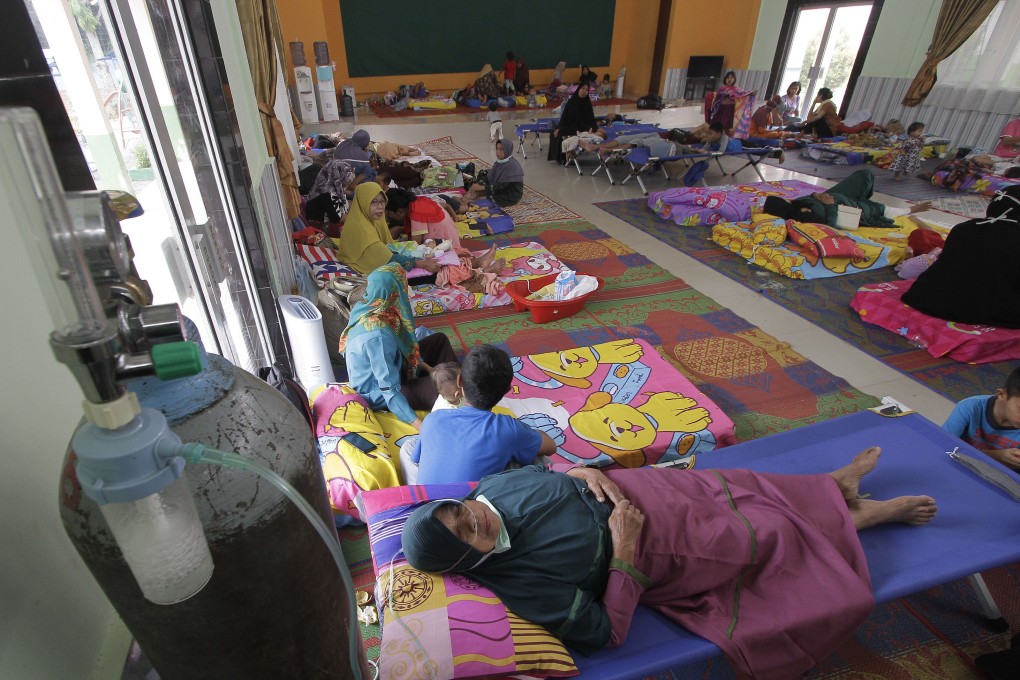 A woman (front) receives oxygen therapy at a temporary shelter after being exposed to smoke from a forest fire in Riau, Indonesia, on Sunday. Photo: Xinhua