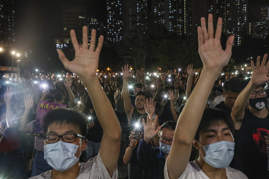 Anti-government protesters hold up their hands to symbolise the “five demands”, as they switch on their mobile phone flashlights and sing “Glory to Hong Kong”, outside an MTR mall in Wong Tai Sin on September 10. Photo: Sam Tsang