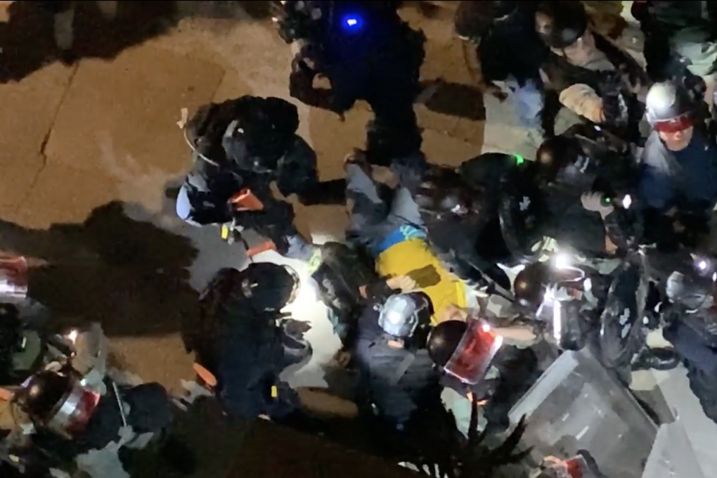 A screen grab shows a man in a yellow vest surrounded by police officers in Yuen Long on Saturday. Photo: Facebook