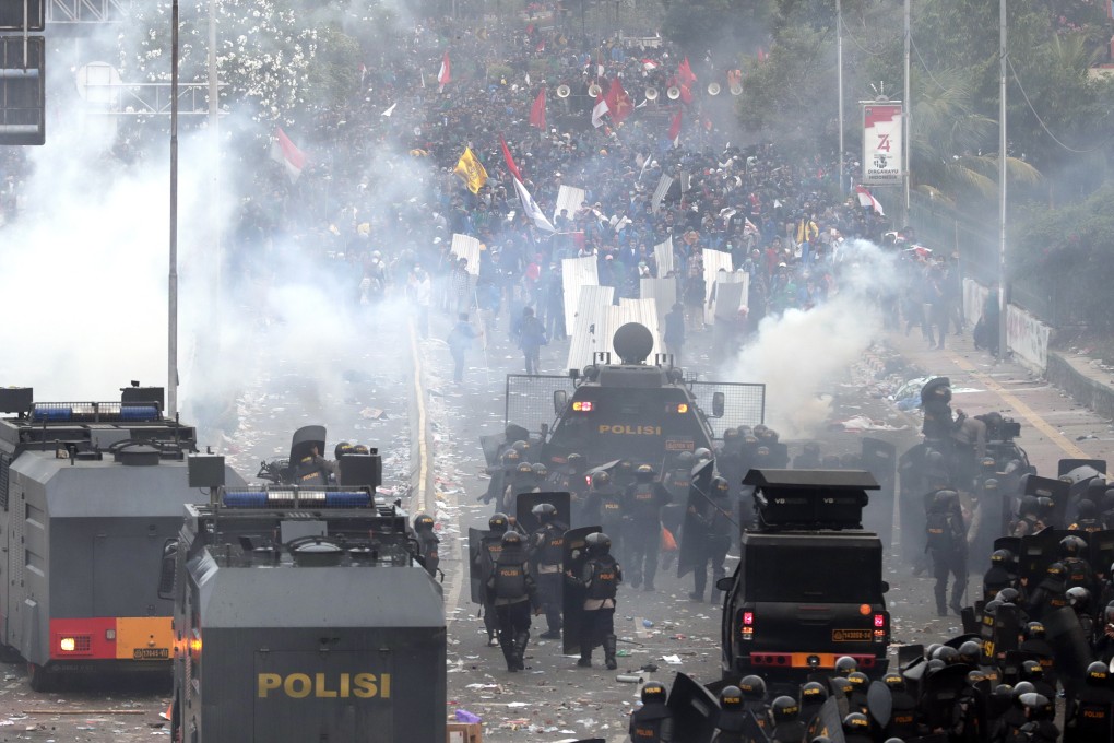 Indonesian riot police officers shoot tear gas during clashes with students outside the parliament building in Jakarta. Photo: EPA-EFE