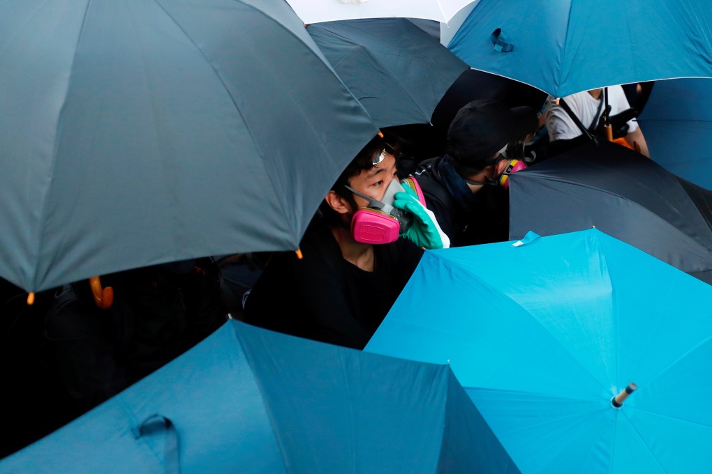 Anti-government protesters hold umbrellas during a stand-off with riot police outside New Town Plaza in Sha Tin. Photo: Reuters