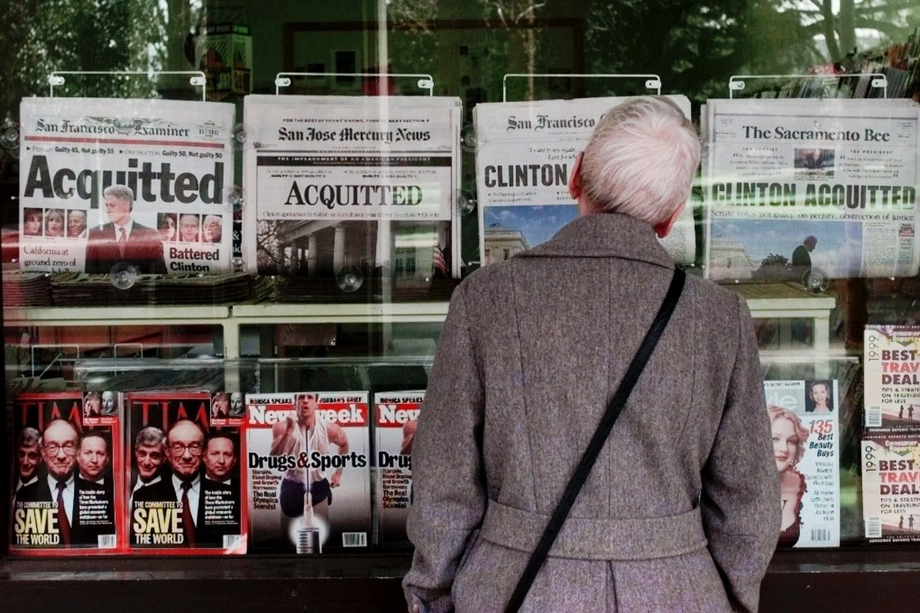 A woman views newspaper headlines announcing the acquittal of President Bill Clinton in 1999. File photo: AP