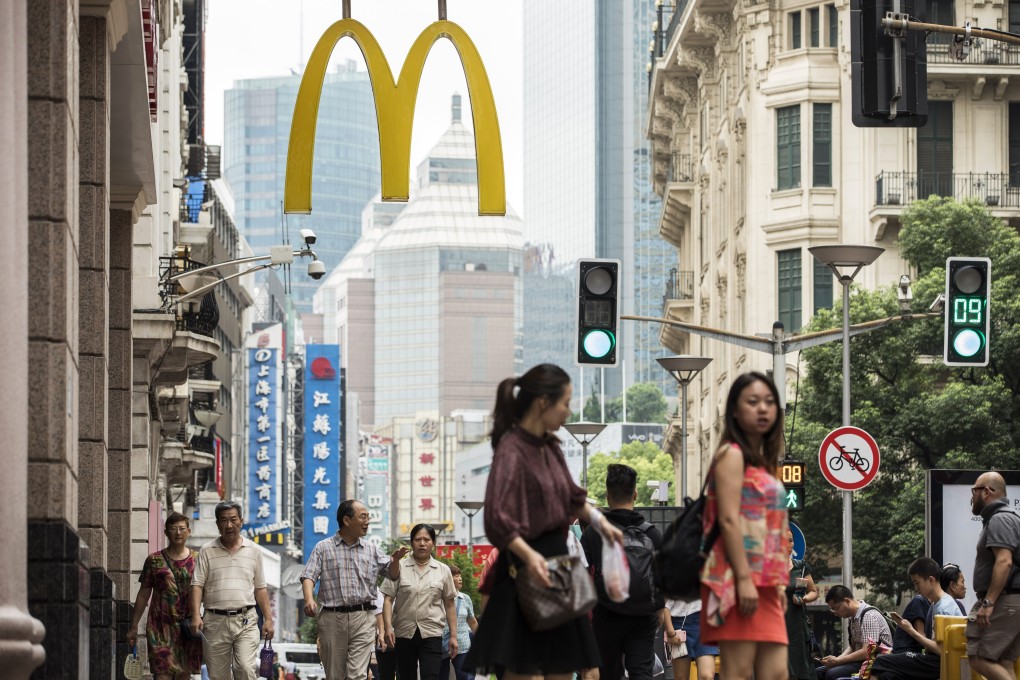 Pedestrians and shoppers walk past a McDonald’s restaurant in Shanghai. The fast-food chain’s revenues in China have grown as consumers increasingly order food using online delivery apps. Photo: Bloomberg