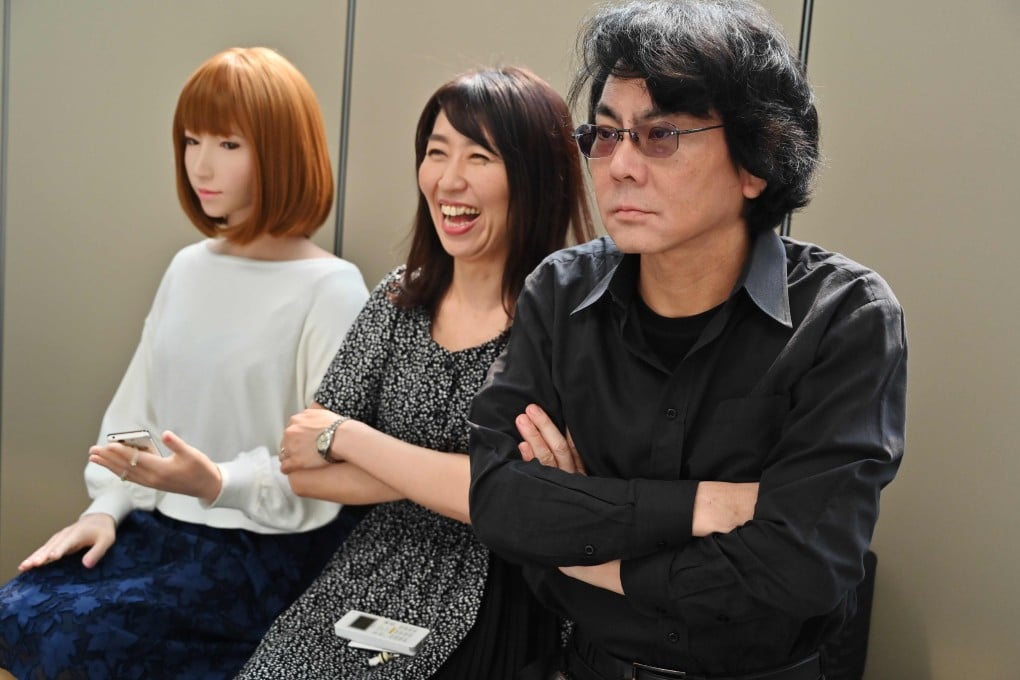Japanese roboticist Hiroshi Ishiguro (right) sits with an assistant (centre) and one of his robots (left) at his research centre in Osaka, Japan. Photo: AFP