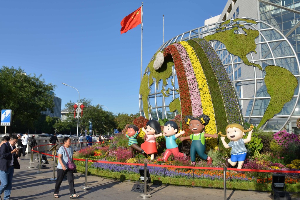 People pass by a flower bed titled “Community with a Shared Future” in Beijing on September 24, one of 12 such beds built along Changan Avenue to celebrate the 70th anniversary of the founding of the People's Republic of China. Photo: Xinhua