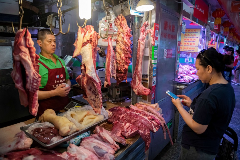 A customer pays a butcher using her smartphone at a market in Beijing. Photo: AFP