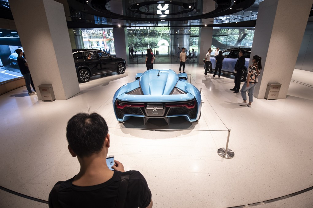 Customers look on as Nio’s EP9 sports car stands on display inside the company’s showroom at the Shanghai Tower in Shanghai. The electric car maker reported a larger-than-expected loss of 3.3 billion yuan in the second quarter. Photo: Bloomberg