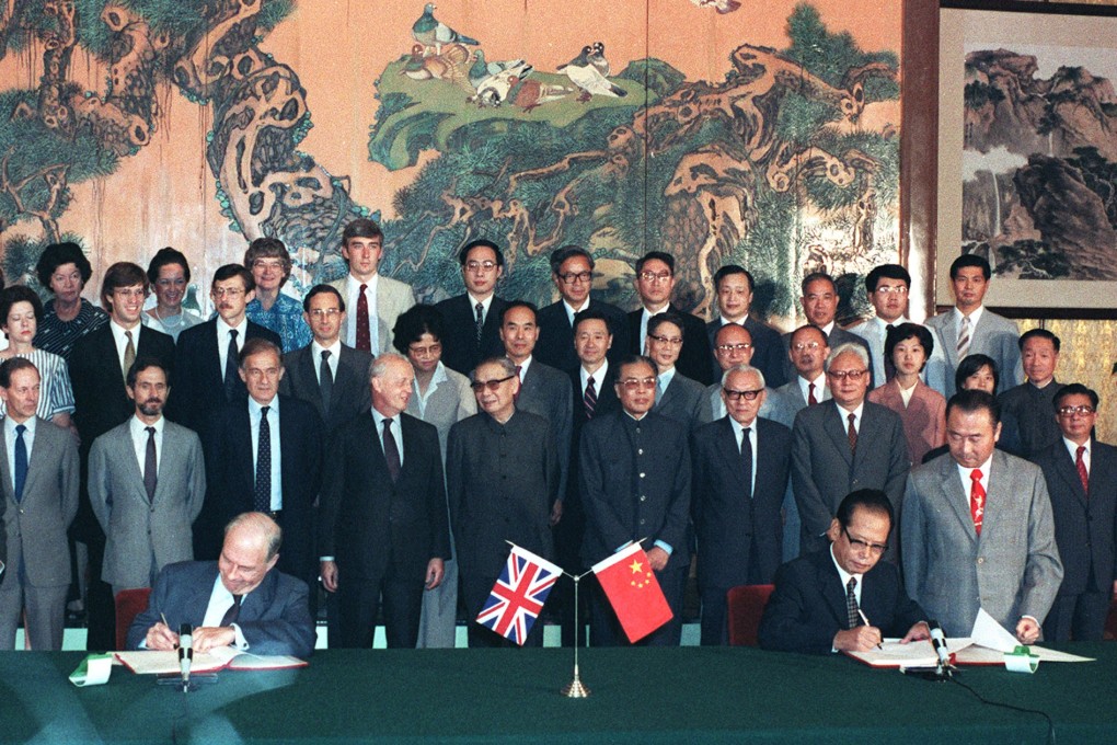 In Beijing, chairman of the Chinese negotiating team Zhou Nan (seated right)and leader of the British side, Sir Richard Evans, sign the draft agreement of the Sino-British Joint Declaration on September 26, 1984.