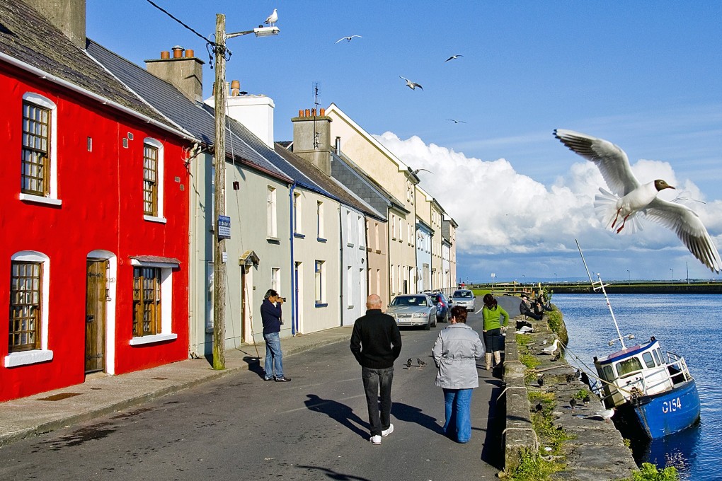 A row of brightly painted houses facing Galway Bay known as the Long Walk, in Galway, Ireland. Photo: Tim Pile