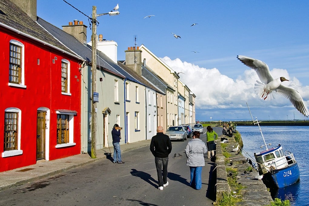 A row of brightly painted houses facing Galway Bay known as the Long Walk, in Galway, Ireland. Photo: Tim Pile