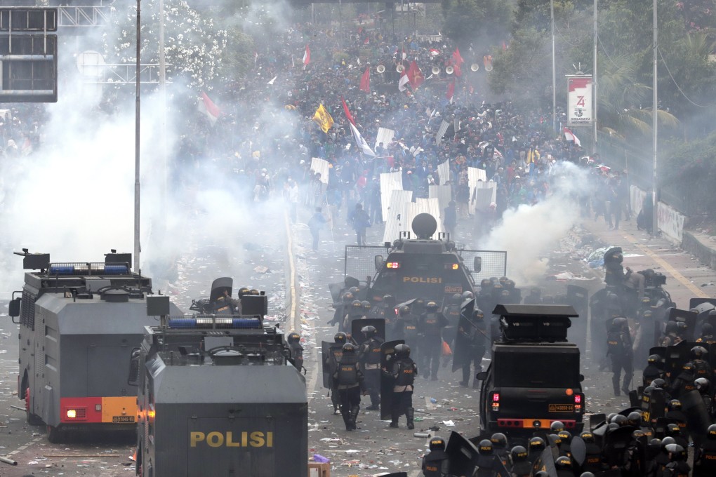 Indonesian riot police officers fire tear gas during clashes with students following a protest outside the parliament building in Jakarta on September 24. Photo: EPA