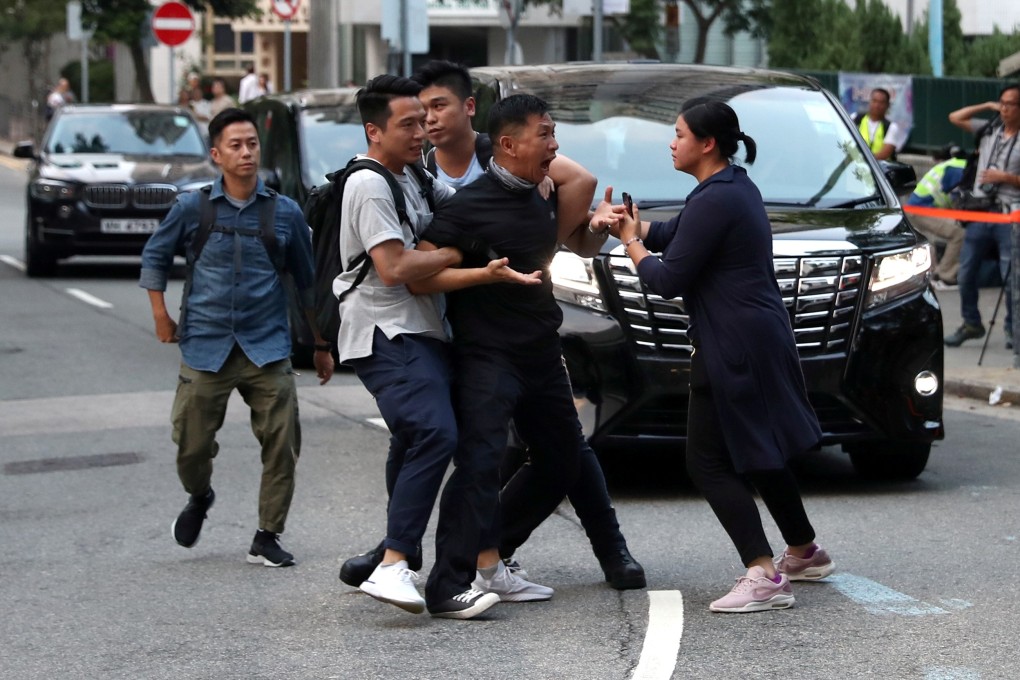 A protester is escorted by undercover police officers after he tries to stop Chief Executive Carrie Lam's motorcade on September 26. Photo: Reuters