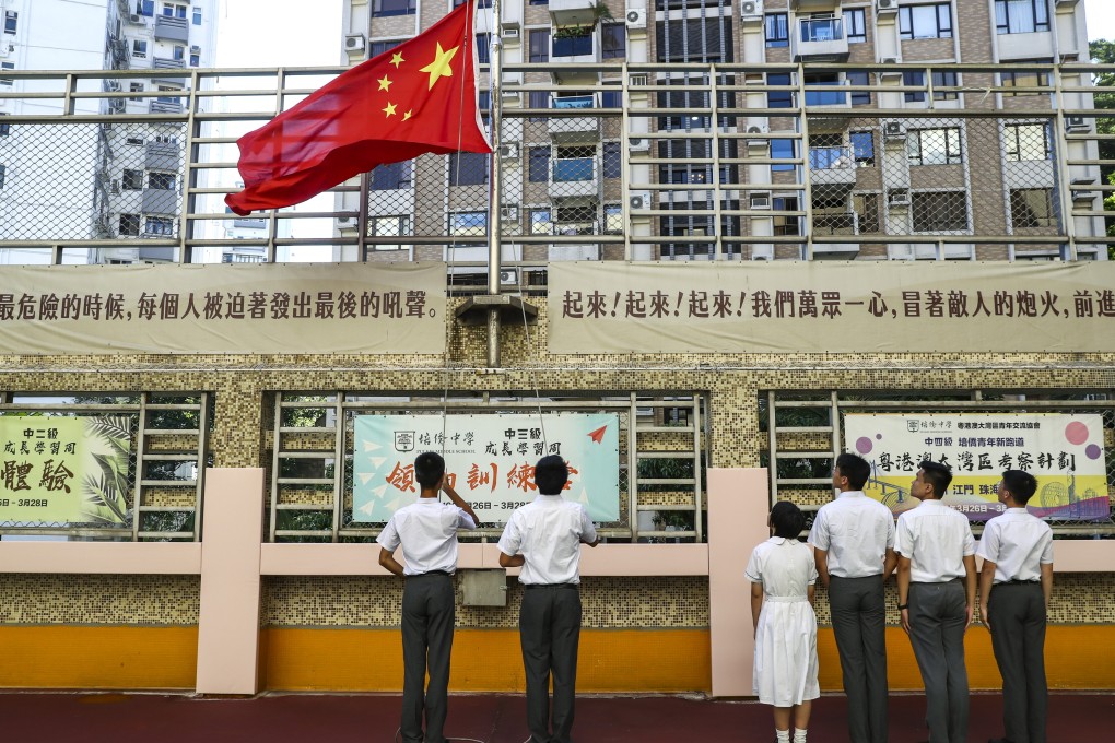 Students from Pui Kiu Middle School in North Point observe the national flag-raising ceremony on campus. Chief Executive Carrie Lam has said schools cancelling National Day flag-raising ceremonies will send out an “incorrect message”. Photo: Nora Tam