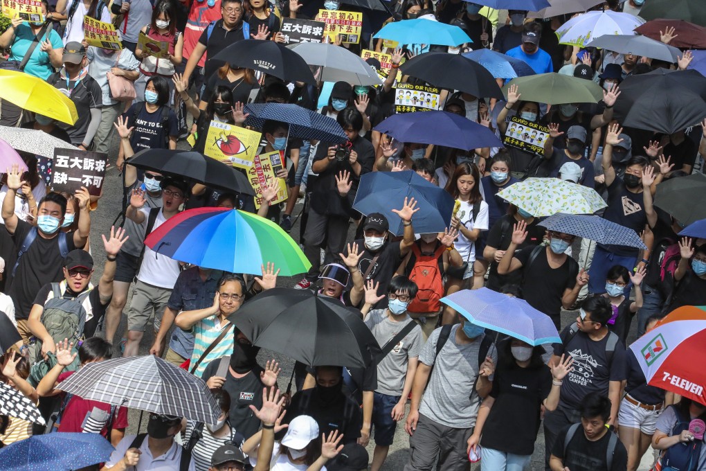 Protesters hold up the hands symbolising their five demands during a march in Hong Kong. Photo: Felix Wong