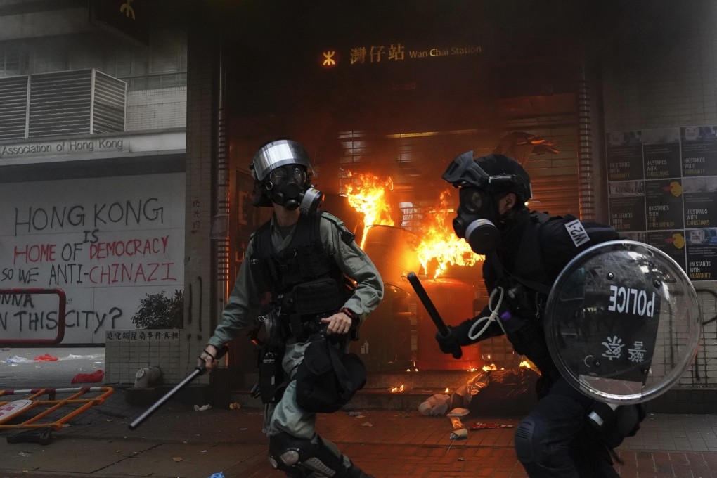Riot police arrive after protesters start a fire at the exit to Wan Chai MTR station and vandalise public property in Hong Kong on September 29. Police fired tear gas on the day in the Causeway Bay, after a large crowd of protesters ignored warnings to disperse. Photo: AP