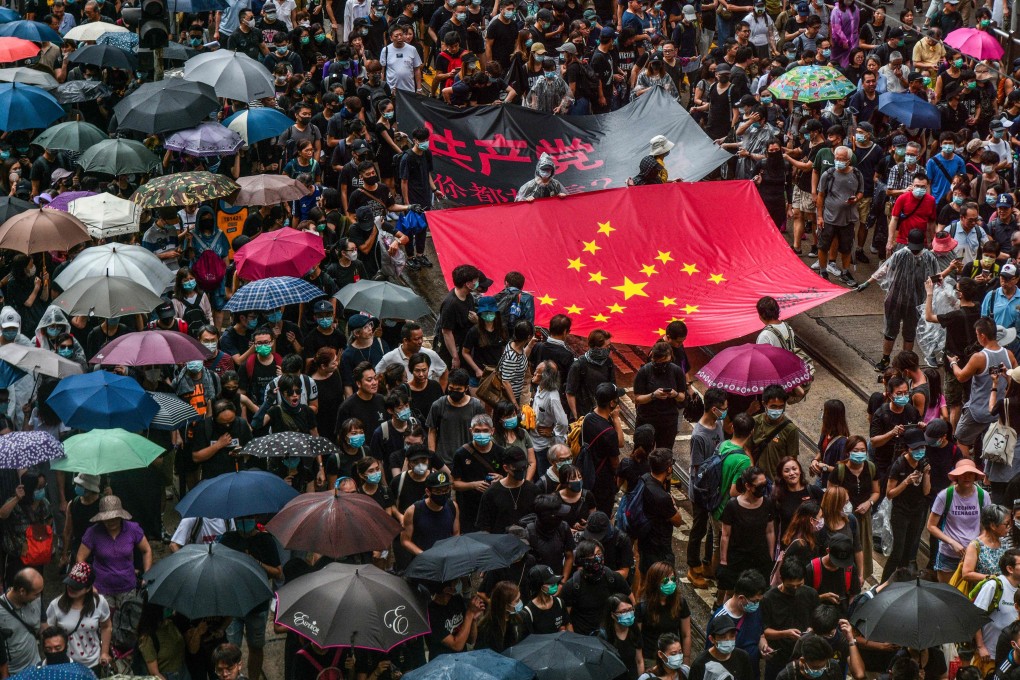 Protesters march in Central in late August with a banner that uses the stars of the Chinese national flag to depict a Nazi swastika symbol. Photo: AFP