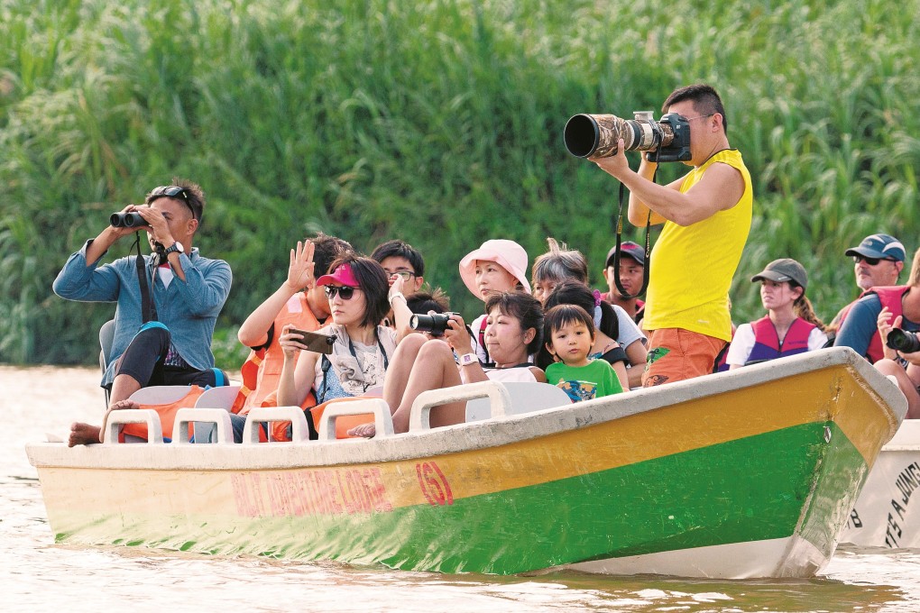 Chinese tourists look at wildlife from boats on the Kinabatangan River, Sabah, Malaysia. There are fears that the Chinese tourism boom in Sabah may end up doing more harm than good. Photo: Alamy