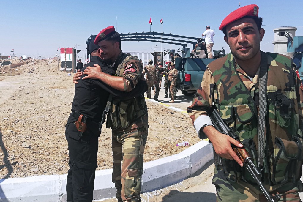 Iraq and Syria border guards embrace each other during the opening ceremony of the crossing. Photo: AP