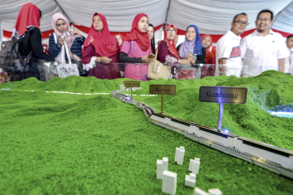 Visitors view a scale model of the East Coast Rail Link during the launching of the train project in Kuantan, Malaysia, in 2017. Malaysia's government, in July 2019, announced the resumption of the China-backed project, which it had suspended the year before, after the Chinese contractor involved agreed to cut construction costs by one-third. Photo: AP