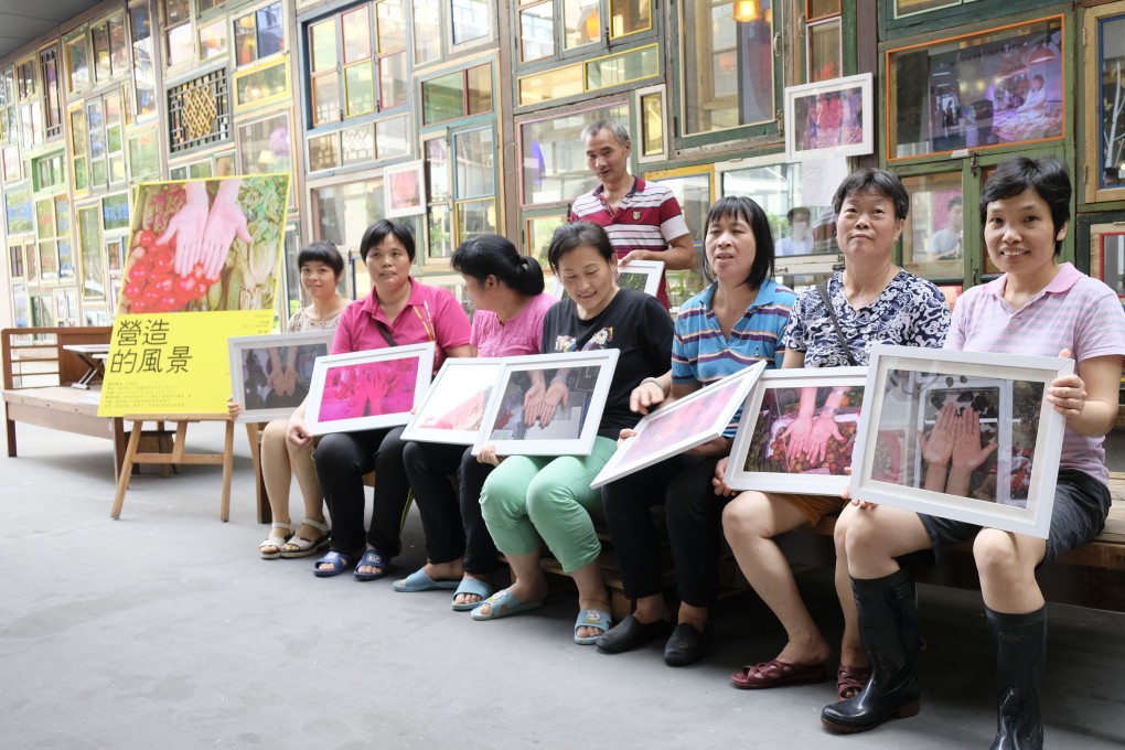 Stall keepers with photographs of their hands in front of artist Song Dong’s wall of glass cabinets, at Fei Gallery, in Guangzhou. Photo: courtesy of Fei Gallery