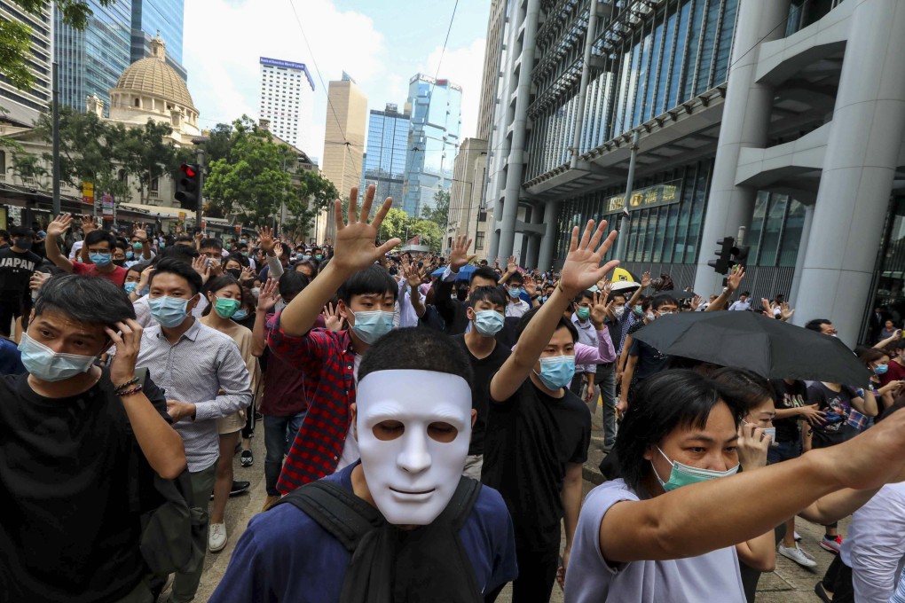 Protesters hold up their hands to symbolise their five demands during a march against an expected government ban on wearing face masks. Photo: Felix Wong