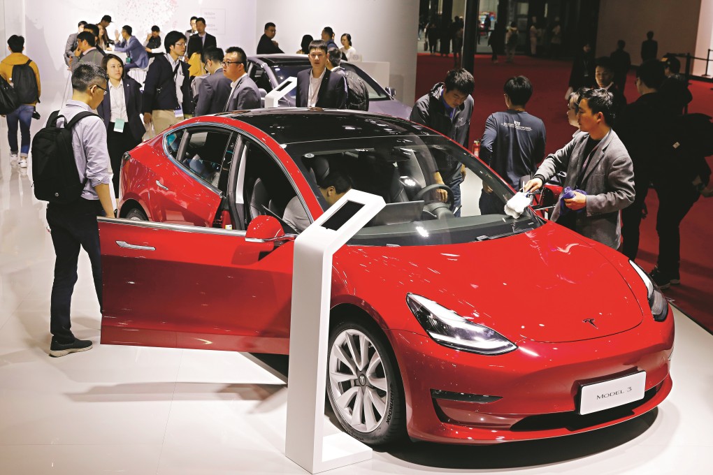 Visitors inspect a Tesla Model 3 during the media day at the Auto Shanghai 2019 motor show in Shanghai, China. Tesla is building a factory in the city. Photo: EPA