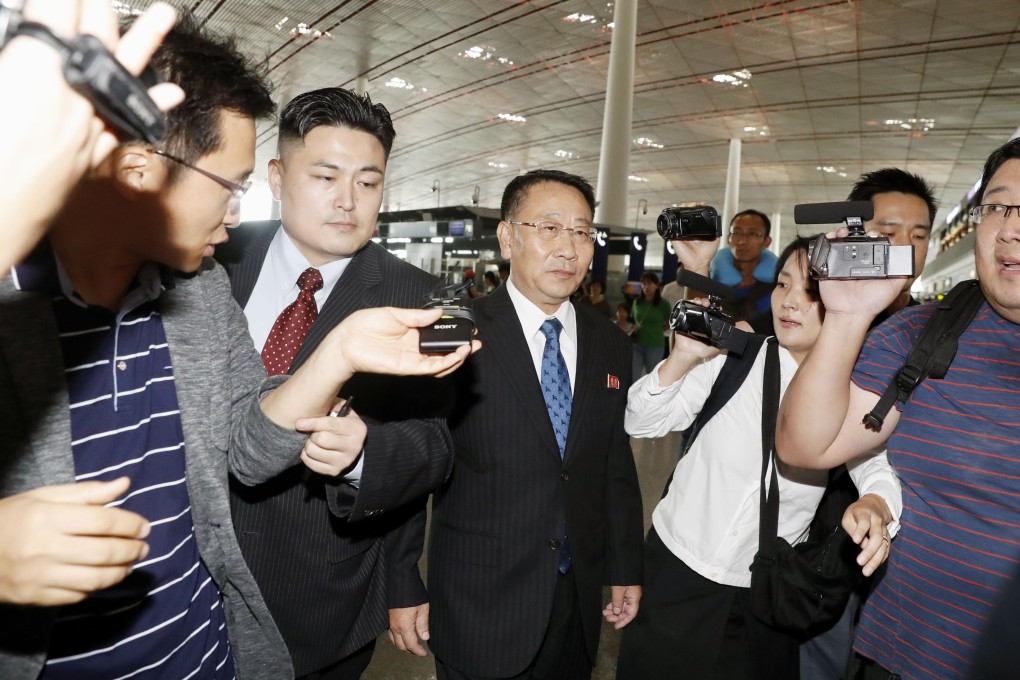 North Korean roving ambassador Kim Myong-gil (centre) at Beijing international airport on Thursday before departing for Stockholm. Photo: Kyodo