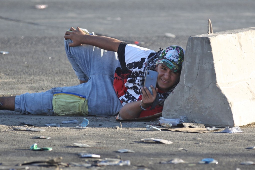 An Iraqi protester takes cover in the Iraqi capital Baghdad's central Khellani Square. Photo: AFP