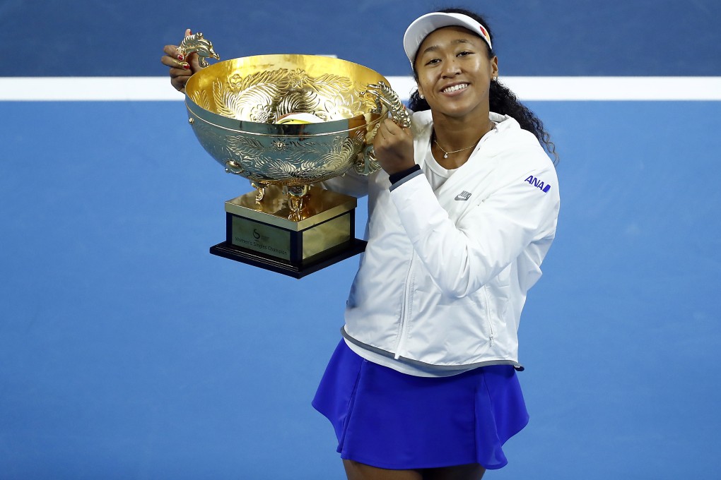 Naomi Osaka celebrates winning the China Open with her trophy in Beijing. Photo: EPA