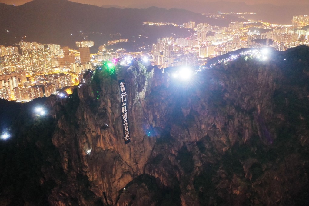 Protesters hang a banner calling for universal suffrage and form a human chain on Lion Rock on September 13. Photo: Martin Chan