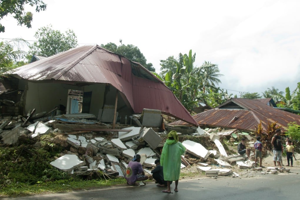 Residents stand near earthquake-damaged houses in Ambon, Maluku province, Indonesia. Photo: AP