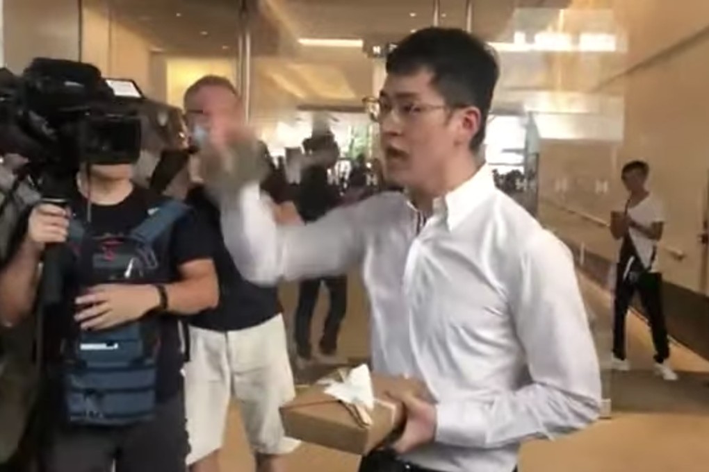 A screen shot from a video of a JPMorgan banker, holding his lunchbox, just before he was punched so hard, he lost his glasses, on October 4. To Hong Kong’s shame, no one in the crowd on onlookers came to his defence. Photo: Handout