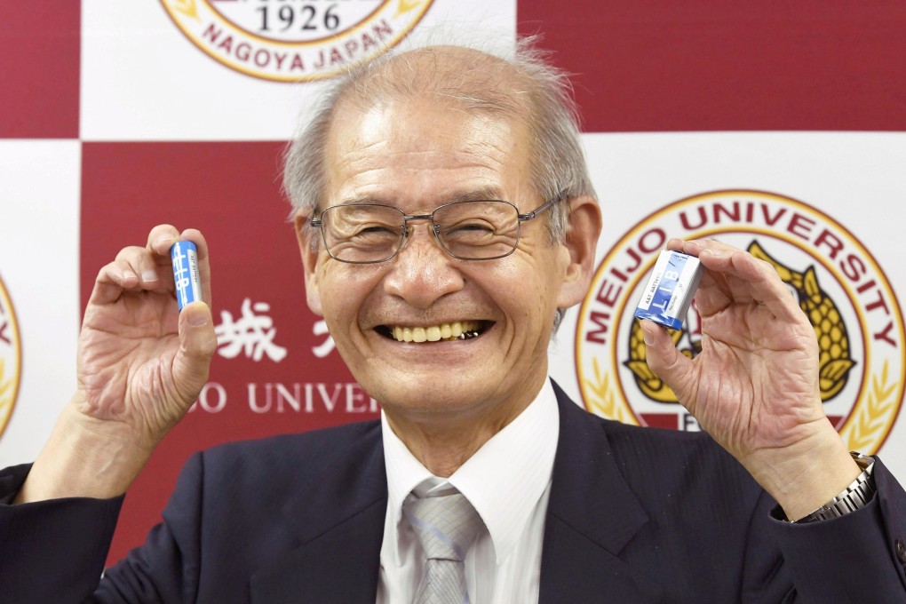 Dr Akira Yoshino holds up a couple of lithium ion batteries. File photo: Kyodo via Reuters