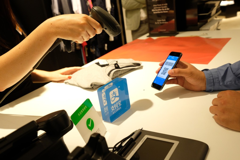 A customer using Alibaba's Alipay at a Breuninger store in Dusseldorf, Germany, June 29, 2018. Photo: Handout via Xinhua