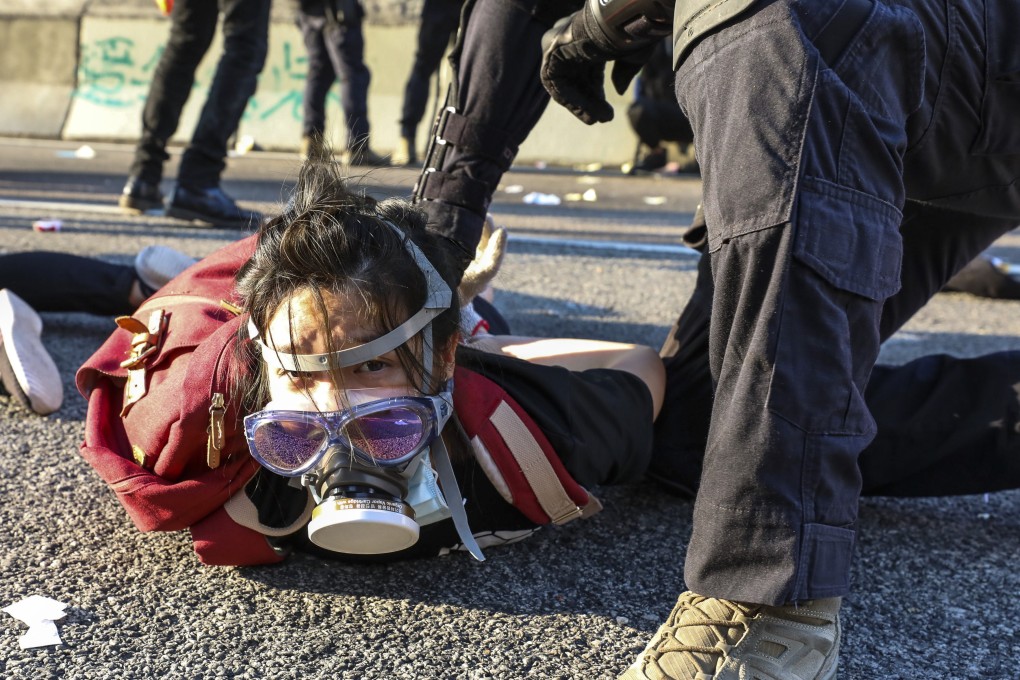 A young protester is held down by a police officer in Wong Tai Sin following scuffles during a mass rally on October 1. Photo: James Wendlinger