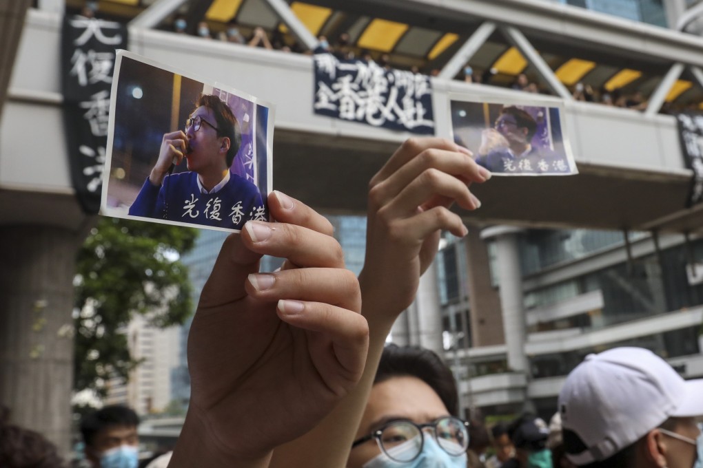 Masked protesters hold photographs of activist Edward Leung, jailed for taking part in the 2016 Mong Kok riots. Photo: Nora Tam