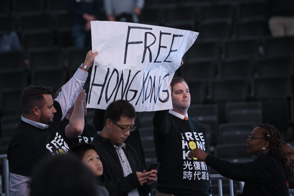 Activists hold up a sign before an NBA exhibition game between the Washington Wizards and the Guangzhou Loong-Lions. Photo: AP