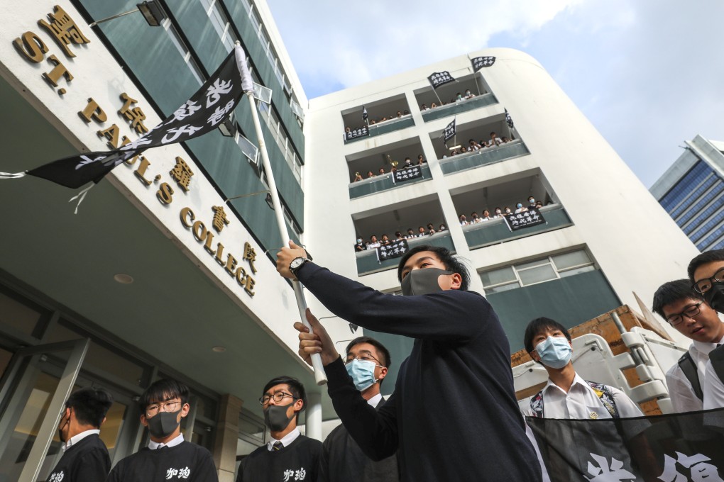 Students at St Paul’s College in Mid-Levels dress in black and wave a “revolutionary” flag. Photo: Robert Ng
