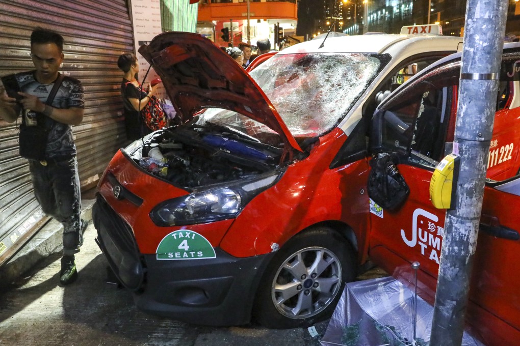 Anti-government protesters damage a taxi and beat up the driver in Sham Shui Po. Photo: K.Y. Cheng