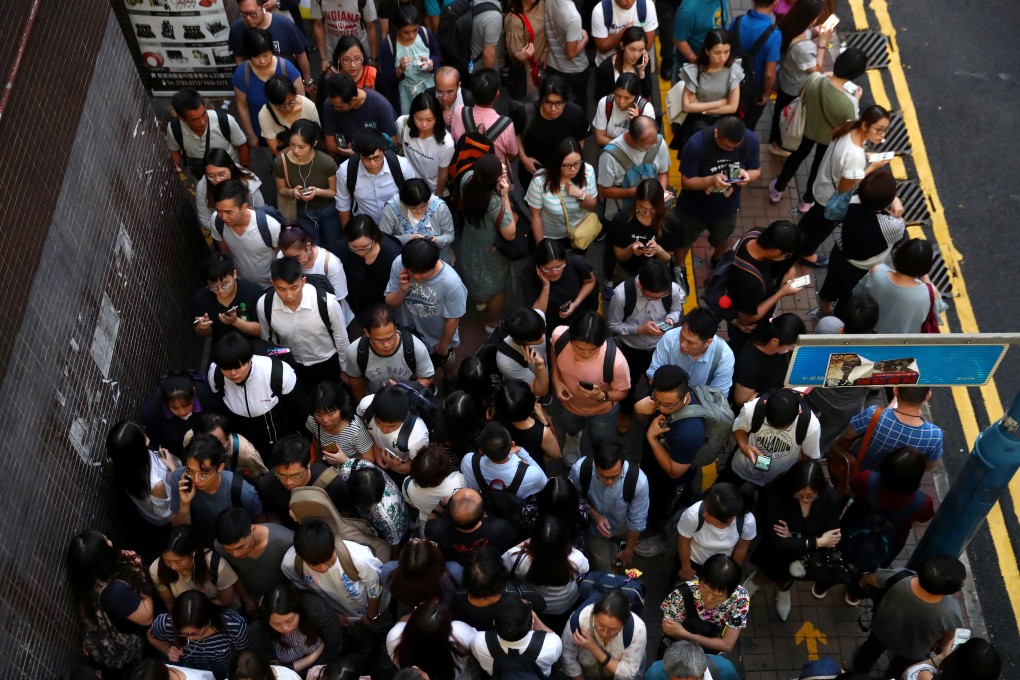 People wait for a bus near Kwun Tong MTR station, which was closed after vandalism. Photo: Reuters